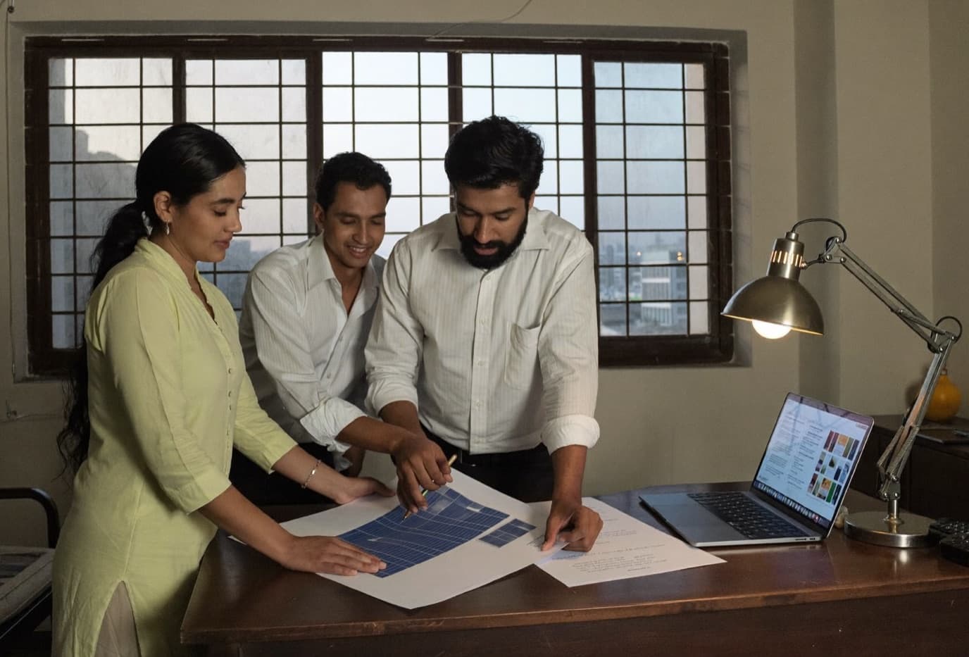 A solar EPC sales team reviewing a project with a customer